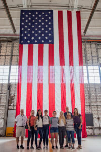studnets in front of large flag