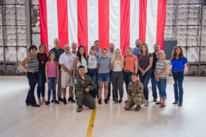 students and military members in front of flag
